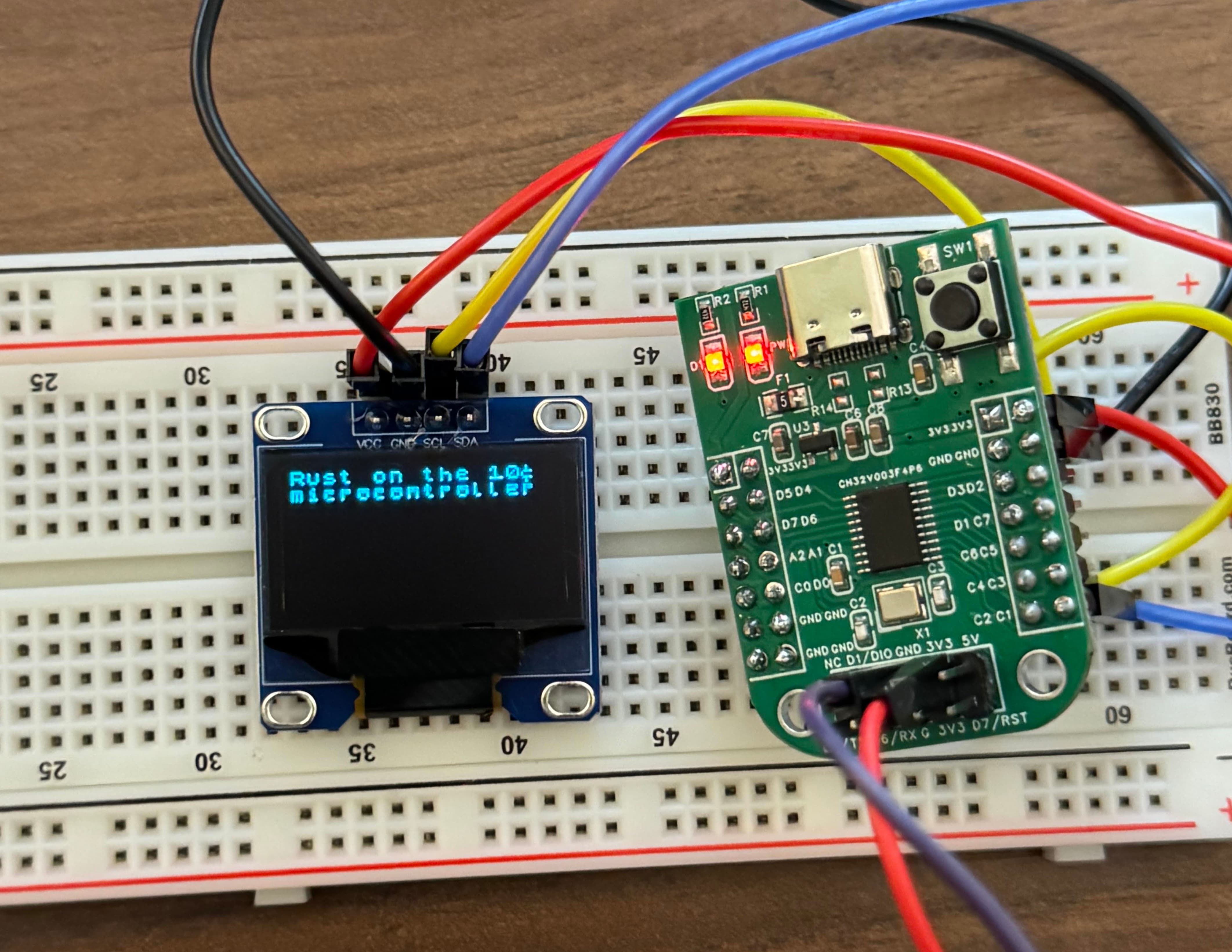 A bread bored with a small little OLED that says Rust on the 10 cent micocontroller